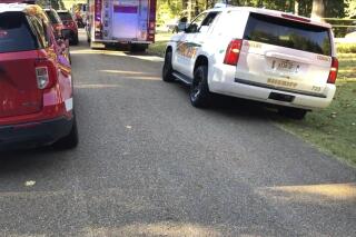 This image provided by Shelby Sheriff's Office shows emergency vehicles at the scene of a dog attack on Wednesday, Oct. 5, 2022 in Shelby, Tenn.  Two young children were killed and their mother was hospitalized after two family dogs attacked them at their home in Tennessee, officials said. (Shelby Sheriff's Office via AP)