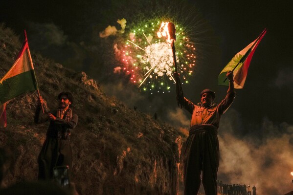 Iraqi Kurds walk up a mountain during a procession to celebrate their Nowruz, the Persian New Year, Akra, in Iraq's northern autonomous Kurdish region, Thursday, March 20, 2025. (AP Photo/Hadi Mizban)