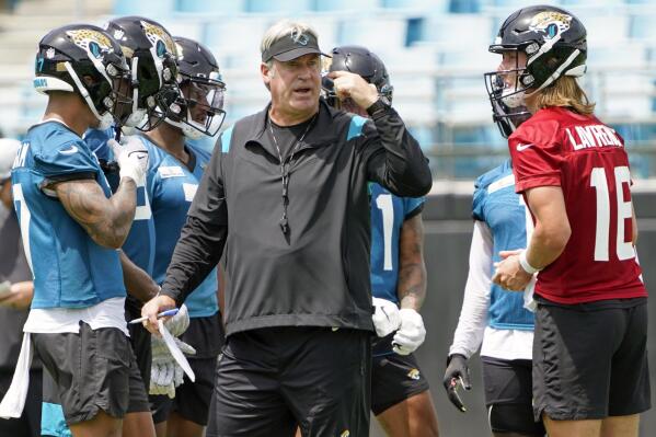 Jacksonville Jaguars head coach Doug Pederson, center, directs an NFL football practice, Monday, May 23, 2022, in Jacksonville, Fla. At right is quarterback Trevor Lawrence. (AP Photo/John Raoux)