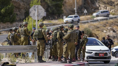 Israeli security forces inspect the scene of a shooting attack near the West Bank Jewish settlement of Tekoa, Sunday, July 16, 2023. Israeli authorities say a Palestinian gunman opened fire on a car in the occupied West Bank wounding three including two girls and sparking a manhunt. (AP Photo/Ohad Zwigenberg)