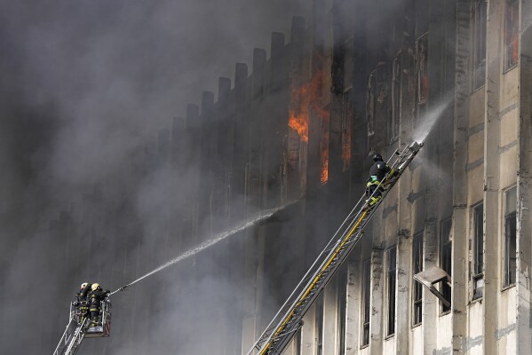 Firefighters tackle a blaze at the site of a Russian attack in Kharkiv, Ukraine, Wednesday, March 20, 2024. (AP Photo/Efrem Lukatsky)