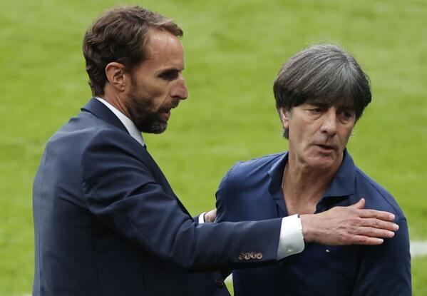England's manager Gareth Southgate, left, hugs with Germany's manager Joachim Loew at the end of the Euro 2020 soccer match round of 16 between England and Germany at Wembley stadium in London, Tuesday, June 29, 2021. (John Sibley/Pool via AP)