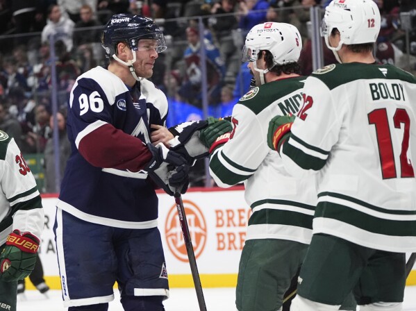 Colorado Avalanche right wing Mikko Rantanen, left, squares off against Minnesota Wild defenseman Jake Middleton before a referee stops the brewing scrum in the third period of an NHL hockey game Monday, Jan. 20, 2025, in Denver. (AP Photo/David Zalubowski)