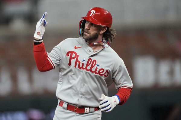 Philadelphia Phillies designated hitter Bryce Harper (3) celebrates hitting a solo homer against the Atlanta Braves during the sixth inning of Game 1 of a baseball NL Division Series, Saturday, Oct. 7, 2023, in Atlanta. (AP Photo/John Bazemore)