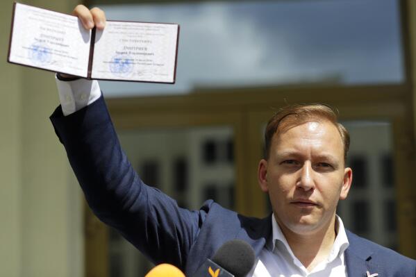 FILE - Andrey Dzmitryeu shows his presidential candidate's identification card after he was registered as a candidate for the presidential elections in Minsk, Belarus, Tuesday, July 14, 2020. A human rights group says an opposition politician who ran against authoritarian leader Alexander Lukashenko has been arrested in Minsk. Andrey Dzmitryeu, a 41-year-old activist who heads the Tell the Truth movement, was seized by security forces near his home in the Belarusian capital Wednesday, Jan. 11, 2023 the Viasna center reported. (AP Photo/Sergei Grits, File)