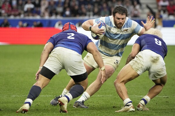 Argentina's captain Julian Montoya, centre, is challenged by Samoa's Seilala Lam, left, and his teammate Jonathan Taumateine during the Rugby World Cup Pool D match between Argentina and Samoa at the Stade Geoffroy Guichard in Saint-Etienne, France, Friday, Sept. 22, 2023. (AP Photo/Laurent Cipriani)