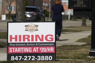 A hiring sign is seen outside of a barber shop in Northbrook, Ill., Tuesday, March 12, 2024. On Thursday, March 28, 2024, the Labor Department issues the latest weekly report on first-time applications for unemployment benefits. (AP Photo/Nam Y. Huh)