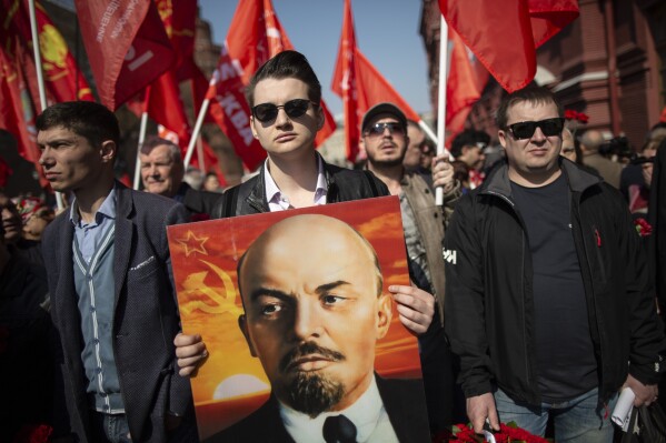 Russian Communists and supporters walk with their flags and a portrait of Vladimir Lenin, the founder of the Soviet Union, to visit his mausoleum in Red Square in Moscow, Russia, to mark the 149th anniversary of his birth, on Monday, April 22, 2019. (AP Photo/Alexander Zemlianichenko, File)