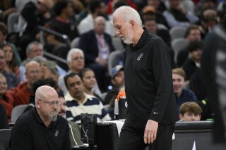 San Antonio Spurs coach Gregg Popovich walks to the bench after addressing fans during the first half of the team's NBA basketball game against the Los Angeles Clippers, Wednesday, Nov. 22, 2023, in San Antonio. (AP Photo/Darren Abate)