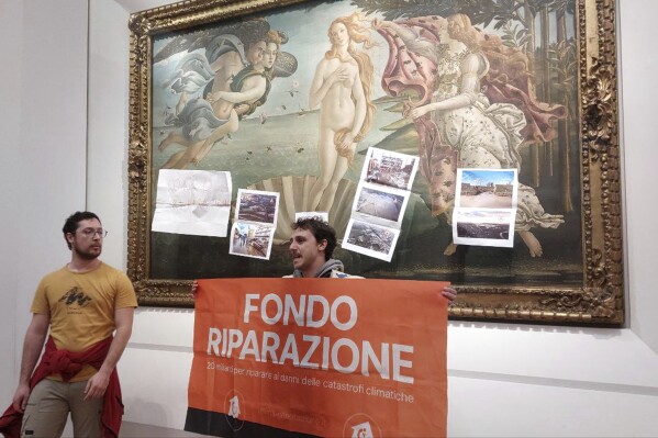 Activists from the Last Generation climate movement protest after attaching materials on the glass protecting Botticelli鈥檚 鈥淭he Birth of Venus鈥� at Florence鈥檚 Uffizi Gallery in Florence, Italy, Tuesday Feb. 13, 2024. Two climate activists on Tuesday targeted Botticelli鈥檚 masterpiece 鈥淭he Birth of Venus鈥� hanging at Florence鈥檚 Uffizi Gallery, attaching images of recent flood damage in the Tuscany region on the protective glass. (Emiliano Benedetti, FirenzeToday via 麻豆传媒app)
