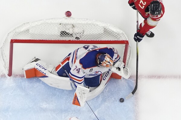 Florida Panthers center Eetu Luostarinen (27) attempts a shot against Edmonton Oilers goaltender Stuart Skinner (74) during the second period of Game 1 of the Stanley Cup Finals, Saturday, June 8, 2024, in Sunrise, Fla. (AP Photo/Wilfredo Lee)
