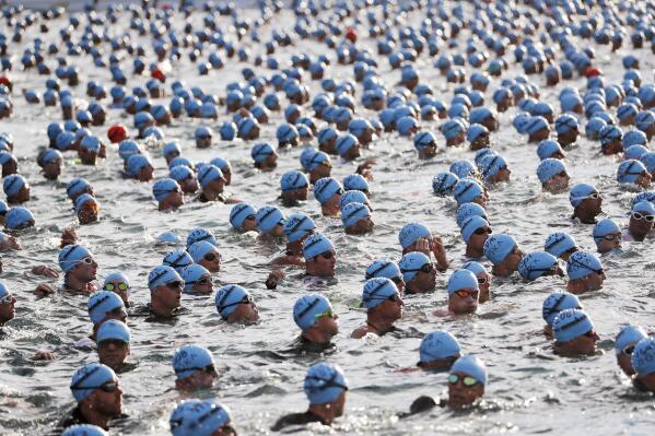FILE - In this Oct. 13, 2018, file photo swimmers await the start of the race at the Ironman World Championship Triathlon, in Kailua Kona, Hawaii. The Ironman World Championship will be held outside Hawaii for the first time in four decades because of uncertainty over whether the Big Island will be able to host the triathlon as scheduled in February during the coronavirus pandemic. Competitors will instead head to St. George, Utah, on May 7. (AP Photo/Marco Garcia, File)