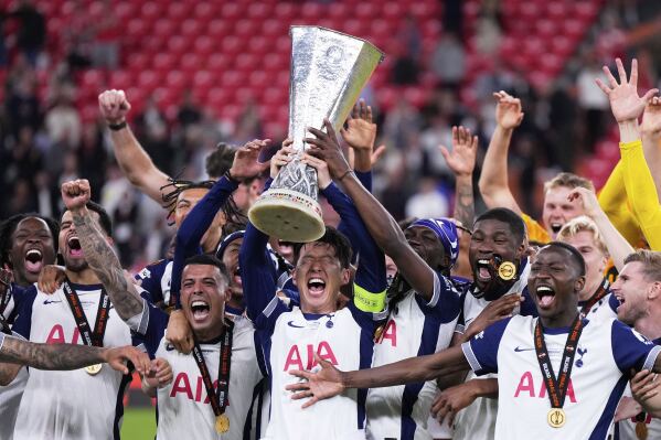 Tottenham's Son Heung-min holds the trophy aloft as he celebrates with teammates after winning the Europa League final soccer match against Manchester United at the San Mames Stadium in Bilbao, Spain, Wednesday, May 21, 2025. (AP Photo/Manu Fernandez)