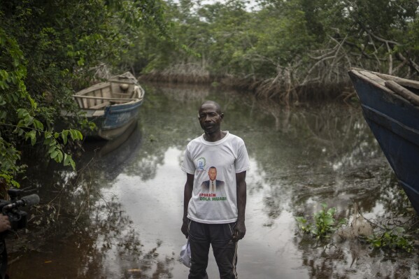 Louis Wolombassa, the chief of Kimpozia village, one of the areas auctioned for oil drilling, poses for a portrait near a mangrove where they rely on fishing, near Moanda, Democratic Republic of the Congo, Monday, Dec. 25, 2023. (AP Photo/Mosa'ab Elshamy)