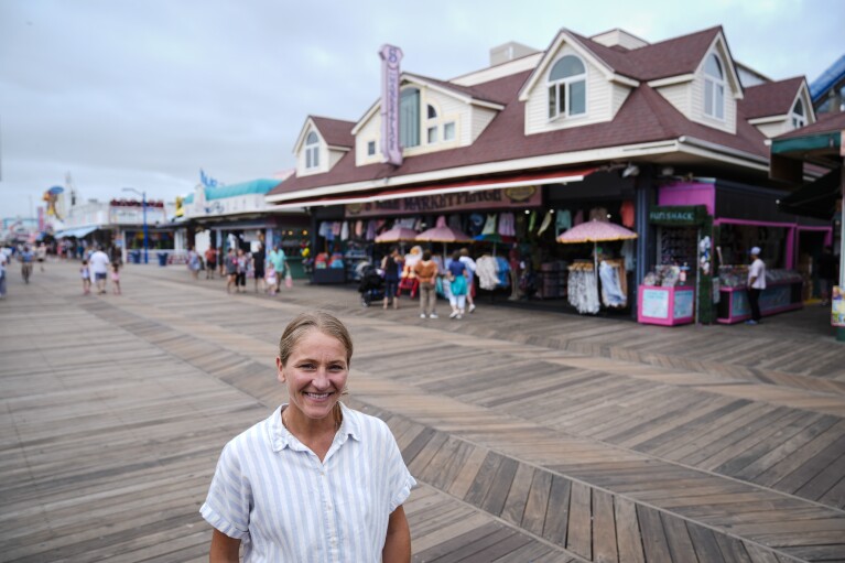 Michelle Rutkowski, who owns Boardwalk Best and Five Mile Marketplace, poses outside her shop in Wildwood, N.J., Friday, Aug. 9, 2024. (AP Photo/Matt Rourke)
