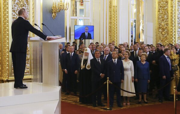 Vladimir Putin speaks with his hand on the Constitution during his inauguration ceremony as new Russia's president in the Grand Kremlin Palace in Moscow, Russia, Monday, May 7, 2018. Putin took the oath of office for his fourth term as Russian president on Monday and promised to pursue an economic agenda that would boost living standards across the country. (Yekaterina Shtukina, Sputnik, Kremlin Pool Photo via AP)