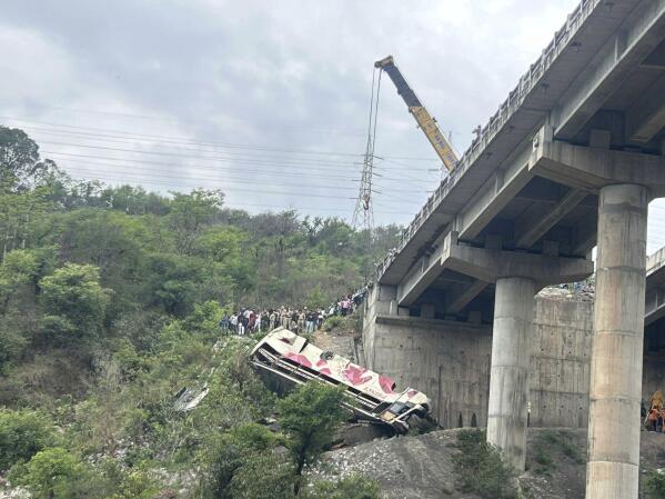 Rescuers prepare to use a crane after a bus carrying Hindu pilgrims to a shrine skid off a highway bridge into a Himalayan gorge near Jammu, India, Tuesday, May 30, 2023. (AP Photo/Channi Anand)