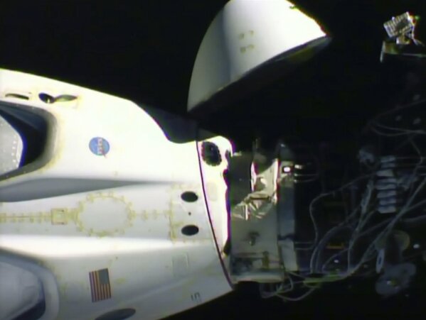 This image from video made available by NASA shows the SpaceX Crew Dragon capsule, left, before it undocks from the International Space Station on Saturday, Aug. 1, 2020. (NASA via AP)