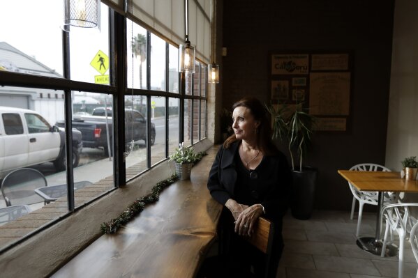 
              In this Nov. 28, 2017, image, Laurie Britton, owner of Cafe Virtuoso, pauses for a portrait as she works in her coffee shop in downtown San Diego. Britton has faced a deluge of problems related to the homeless population around her organic coffee roasting business. Since the city started cleaning up the streets, business has increased by 20 percent. She now welcomes the new giant tents to house the homeless - two of which will be within a block - if people end up in permanent housing. (AP Photo/Gregory Bull)
            