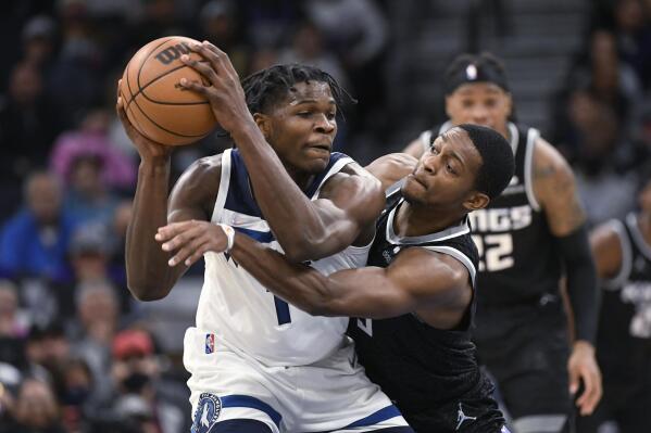 Sacramento Kings guard De'Aaron Fox, right, tries to slap the ball away from Minnesota Timberwolves guard Anthony Edwards during the second half of an NBA basketball game Wednesday, Nov. 17, 2021, in Minneapolis. The Timberwolves won 107-97. (AP Photo/Craig Lassig)