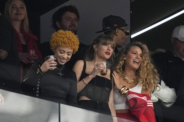 Taylor Swift, center, watches the teams before the NFL Super Bowl 58 football game between the San Francisco 49ers and Kansas City Chiefs with Ice Spice and Blake Lively on Sunday, February 11, 2024, in Las Vegas.  (AP Photo/Ashley Landis)