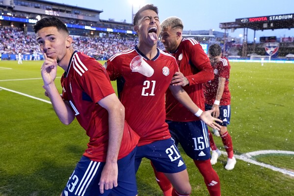Costa Rica midfielder Jefferson Brenes, from left, Alvaro Zamora (21), Francisco Calvo (15) and Joseph Mora (8) are pelted with drinks and trash after celebrating a Brenes goal in the second half of a CONCACAF Nations League Play-In soccer match against Honduras, Saturday, March 23, 2024, in Frisco, Texas. (AP Photo/Julio Cortez)