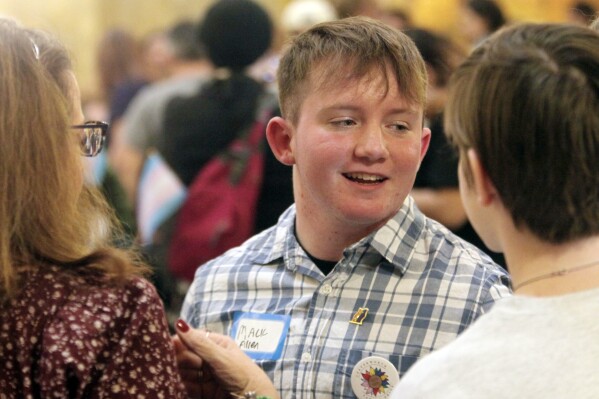 Mack Allen, of Leavenworth, Kan., speaks with friends and family following a rally for LGBTQ youth at the Statehouse, Wednesday, Jan. 31, 2024, in Topeka, Kan. Allen, 18, is transgender, and he says he's been challenged when he's been forced to use women's restrooms in public spaces. (AP Photo/John Hanna)