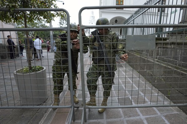 Soldiers close a gate at Carondelet government palace, the presidential office and residence in Quito, Ecuador, Wednesday, Jan. 10, 2024. The government has said at least 30 attacks have taken place since authorities announced that Los Choneros gang leader Adolfo Macías, alias Fito, was discovered missing from his cell in a low-security prison Sunday. (AP Photo/Dolores Ochoa)