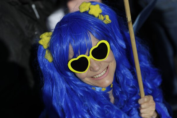 A woman wears the colors and stars of the EU flag as she and other anti-Brexit supporters march in London, Saturday, Oct. 19, 2019. In their first weekend session in 37 years, British lawmakers in Parliament debated whether to accept Prime Minister Boris Johnson's proposed new divorce deal with the European Union. (AP Photo/Kirsty Wigglesworth)