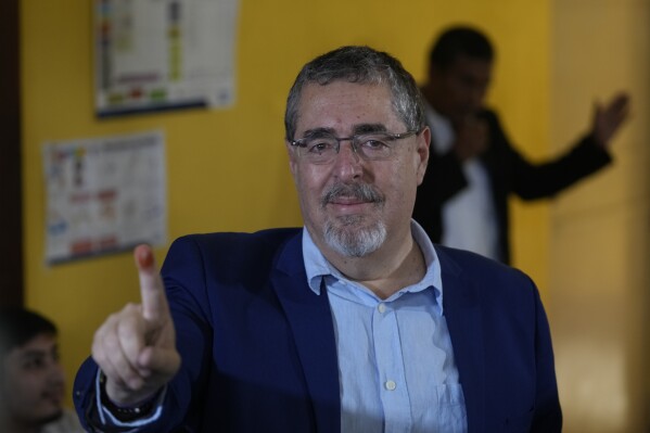 Bernardo Arevalo, presidential candidate with the Semilla Movement, shows his finger dyed with electoral ink after voting in the run-off presidential election in Guatemala City, Sunday, Aug. 20, 2023. (AP Photo/Moises Castillo)