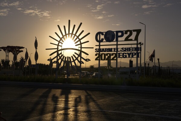 FILE - The sun sets behind the COP27 logo outside the venue of the COP27 U.N. Climate Summit, Saturday, Nov. 12, 2022, in Sharm el-Sheikh, Egypt. As United Nations leaders, scientists and others called for an eventual elimination of coal, oil and natural gas, various delegations at the conference were connected to those fossil fuel industries. (AP Photo/Peter Dejong, File)