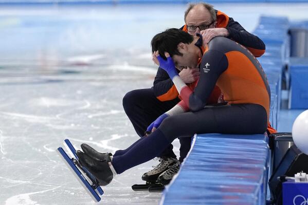 Kai Verbij of the Netherlands is comforted by coach Jac Orie after his heat in the men's speedskating 1,000-meter finals at the 2022 Winter Olympics, Friday, Feb. 18, 2022, in Beijing. (AP Photo/Sue Ogrocki)