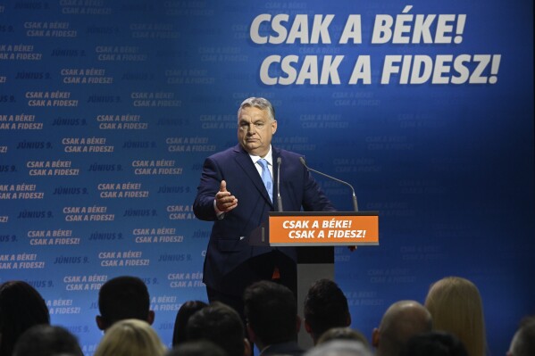 Hungarian Prime Minister and Chairman of Fidesz party Viktor Orban addresses a rally launching the campaign of the party for the European Parliamentary and the local elections in Budapest, Hungary, Friday, April 19, 2024. The inscription reads The peace only! The Fidesz only! Hungarian Prime Minister Viktor Orbán on Friday painted a grim picture of a continent teetering on the edge of armed conflict in a speech opening his party's campaign for European Union elections. He called for a changing of the guard among the bloc's leaders. (Szilard Koszticsak/MTI via AP)