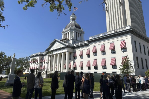 Mourners line up outside the historic Old Capitol building in Tallahassee, Fla., on Friday morning, April 26, 2024, for a memorial service for former U.S. Sen. Bob Graham, who died April 16. Graham, a Democrat, also served as Florida governor before his election to the U.S. Senate. (AP Photo/Brendan Farrington)