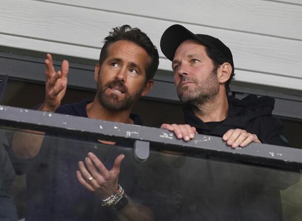 Wrexham co-owner Ryan Reynolds, left, and Paul Rudd in the stands during the National League soccer match between Wrexham and Boreham Wood at The Racecourse Ground, in Wrexham, Wales, Saturday April 22, 2023. (Martin Rickett/PA via AP)
