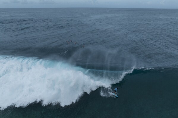 A surfer rides a wave in Teahupo'o, Tahiti, French Polynesia, Saturday, Jan. 13, 2024. The world-famous surf spot is set to host the 2024 Paris Olympics surfing competition. (AP Photo/Daniel Cole)