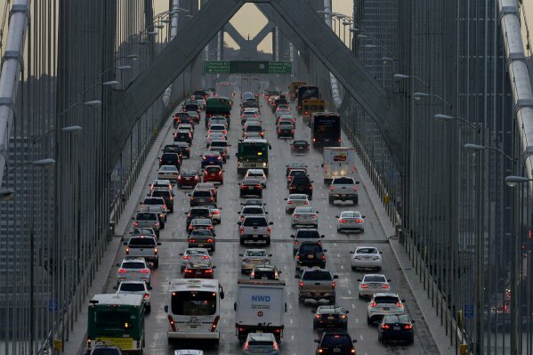 FILE - In this Dec. 10, 2015, file photo, vehicles make their way westbound on Interstate 80 across the San Francisco-Oakland Bay Bridge as seen from Treasure Island in San Francisco. Major automakers are urging the Trump administration and California to go back to the negotiating table over vehicle mileage standards to prevent a legal battle. The companies sent letters Thursday, June 6, 2019, to President Donald Trump and California Gov. Gavin Newsom saying a failure to reach agreement would create instability in the auto market. (AP Photo/Ben Margot, File)