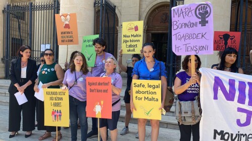 FILE - Activists hold up banners in both English and Maltese reading, 'I decide', 'Abortion is a woman's right', and 'Abortion is healthcare, not a crime', as they stand outside the Maltese law courts in Valletta, Malta, Wednesday, June 15, 2022. Maltese lawmakers are expected to vote Wednesday, June 28, 2023 on landmark legislation to ease the the strictest abortion laws in the European Union. But a coalition of pro-choice campaigners say last-minute changes make the legislation “vague, unworkable and even dangerous.” (AP Photo/Kevin Schembri Orland, File)