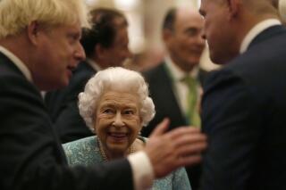 Britain's Queen Elizabeth II and Prime Minister Boris Johnson, left, greet guests at a reception for the Global Investment Summit in Windsor Castle, Windsor, England, Tuesday, Oct. 19, 2021. (AP Photo/Alastair Grant, Pool)