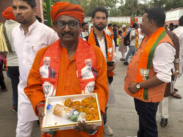 A Bharatiya Janata Party (BJP) worker waits with sweets inside the party office for the final election results to be declared in New Delhi, India, Tuesday, June 4, 2024. Prime Minister Narendra Modi's Hindu nationalist party showed a comfortable lead Tuesday, according to early figures reported by India's Election Commission, but was facing a stronger challenge from the opposition than had been expected. (AP Photo/Manish Swarup)