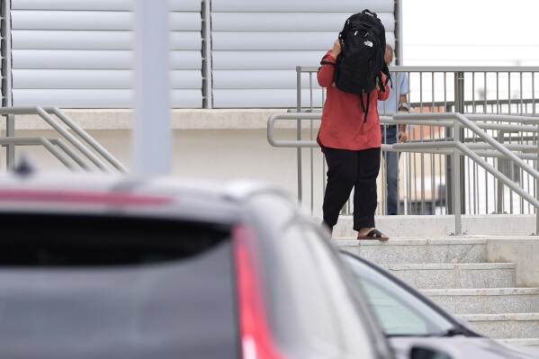 A relative of one from five Israelis who are accused of raping a British woman, cover her face with a bag as leaves the building of the Famagusta District Courthouse in Paralimni, Cyprus, on Tuesday, Sept. 12, 2023. A Cyprus Court on Tuesday has extended for another six days the detention of five Israelis who are accused by a British wan of gang-raping her in a hotel room during a pool party in the coastal resort town of Ayia Napa earlier this month.(AP Photo/Petros Karadjias)