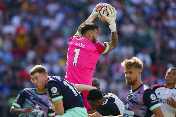Brentford's David Raya (1) leaps above the scrum to grab the ball during the second half of an English Premier League Summer Series soccer match against Fulham, Sunday, July 23, 2023 in Philadelphia. (AP Photo/Chris Szagola)