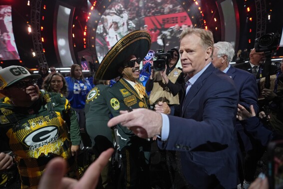 NFL Commissioner Roger Goodell meets with Green Bay Packers fans during the first round of the NFL football draft, Thursday, April 25, 2024, in Detroit. (AP Photo/Paul Sancya)