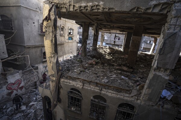 Palestinians check a house destroyed in the Israeli bombardment on Rafah, Gaza Strip, Monday, Dec. 11, 2023. (AP Photo/Fatima Shbair)