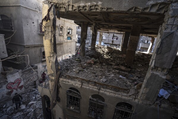 Palestinians check a house destroyed in the Israeli bombardment on Rafah, Gaza Strip, Monday, Dec. 11, 2023. (AP Photo/Fatima Shbair)