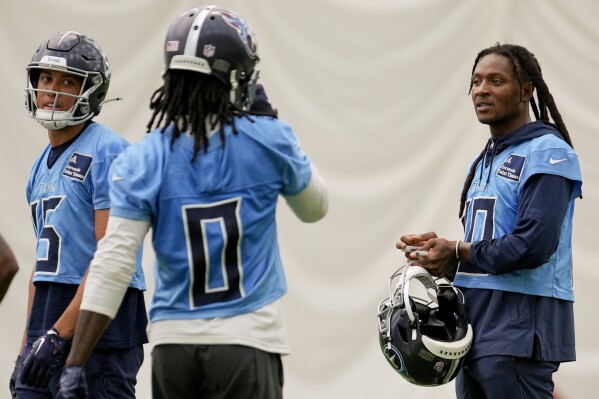 Tennessee Titans wide receiver DeAndre Hopkins, right, talks to teammates Nick Westbrook-Ikhine, left, and Calvin Ridley (0) during NFL football practice Tuesday, June 4, 2024, in Nashville, Tenn. (AP Photo/George Walker IV)
