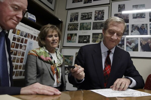 Democratic presidential candidate businessman Tom Steyer files to be placed on the New Hampshire primary ballot at the Statehouse, Tuesday, Nov. 12, 2019, in Concord, N.H. Watching, middle, is Steyer's wife, Kat Taylor, and, far left, is Secretary of State Bill Gardner. (AP Photo/Elise Amendola)