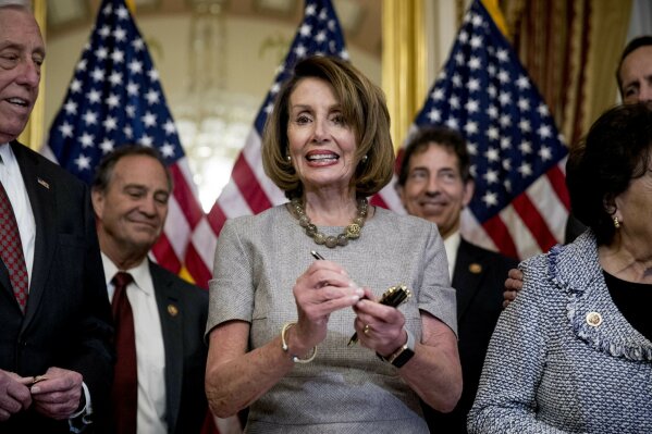 
              House Speaker Nancy Pelosi of Calif., accompanied by House Democratic members stand after signs a deal to reopen the government on Capitol Hill in Washington, Friday, Jan. 25, 2019. The measure now goes to the White House for President Donald Trump to sign.  (AP Photo/Andrew Harnik)
            