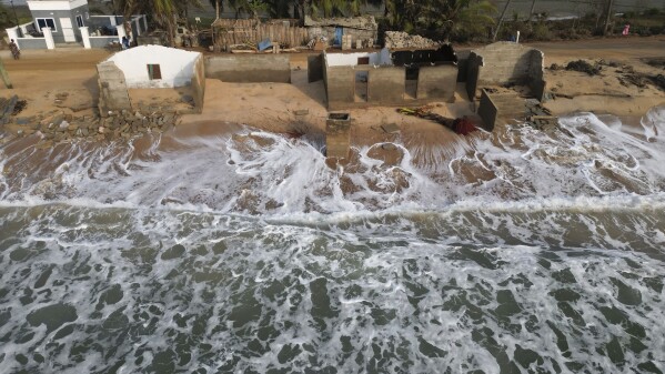 Waves lap the beach where remains of Afeli Bernice Adzo's family home stand after it was destroyed by coastal erosion in Avegadzi, Ghana, Wednesday, March 5, 2025 (AP Photo/Misper Apawu)