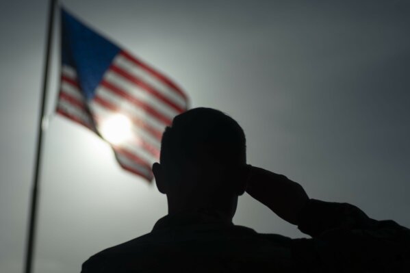 In this photo taken Aug. 26, 2019 and released by the U.S. Air Force, U.S. Air Force Staff Sgt. Devin Boyer, 435th Air Expeditionary Wing photojournalist, salutes the flag during a ceremony signifying the change from tactical to enduring operations at Camp Simba, Manda Bay, Kenya. The al-Shabab extremist group said Sunday, Jan. 5, 2020 that it has attacked the Camp Simba military base used by U.S. and Kenyan troops in coastal Kenya, while Kenya's military says the attempted pre-dawn breach was repulsed and at least four attackers were killed. (Staff Sgt. Lexie West/U.S. Air Force via AP)
